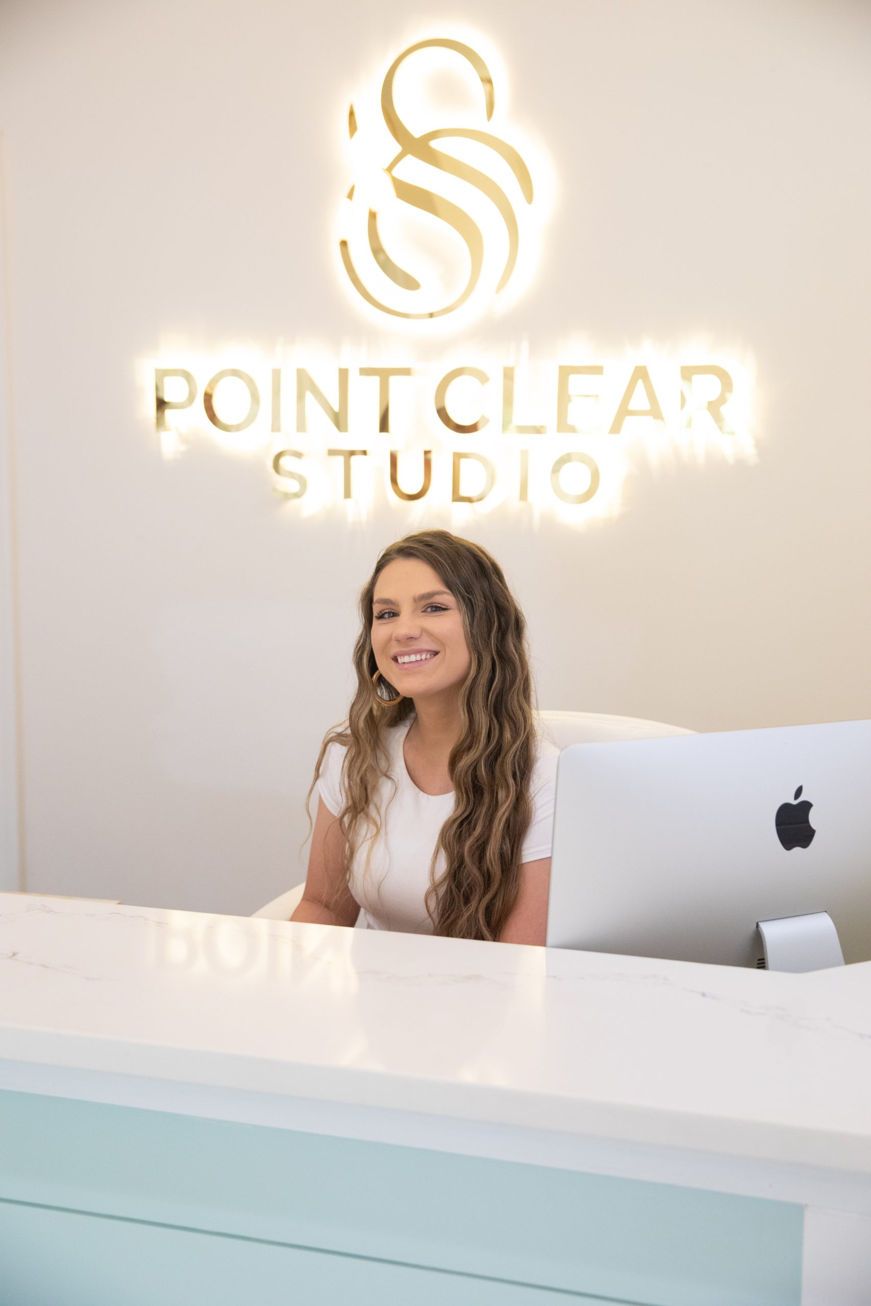 Point Clear office coordinator sitting at desk